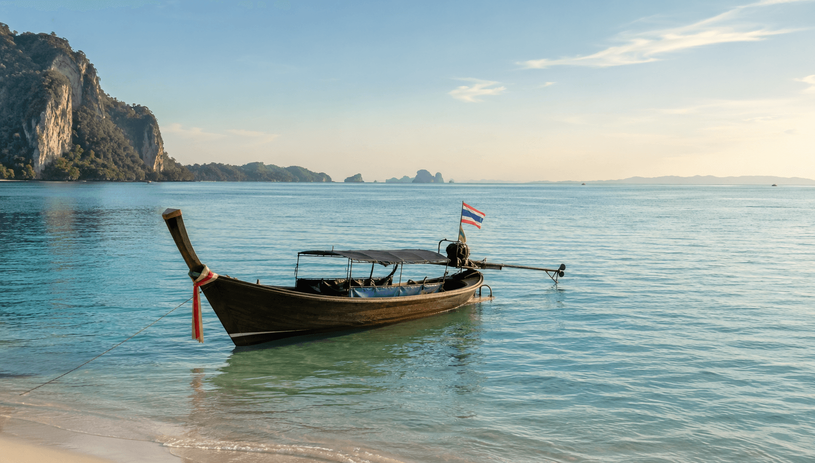 Long-tail boat on calm turquoise water